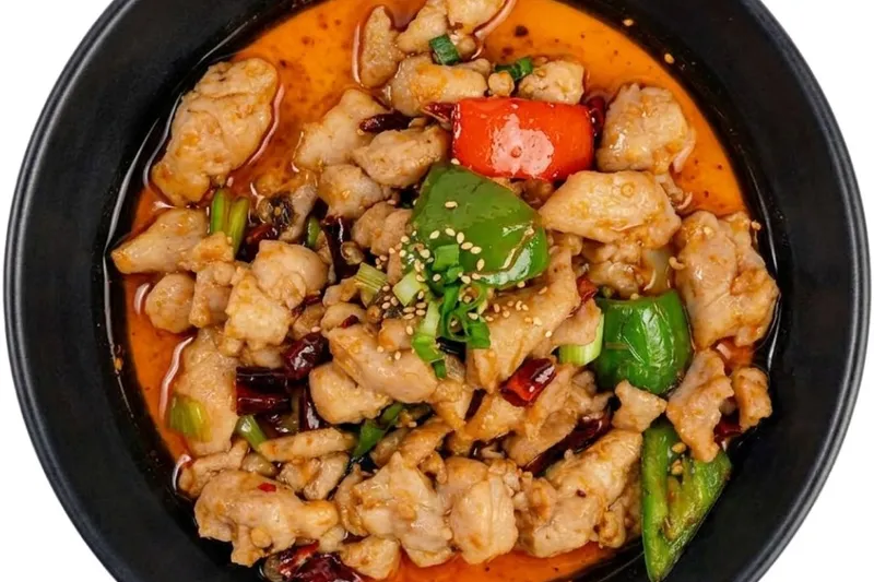 Sichuan diced chicken stir-fried with dried chilies and bell peppers in red chili oil, a dish served at Petals of a Peony in Memphis
